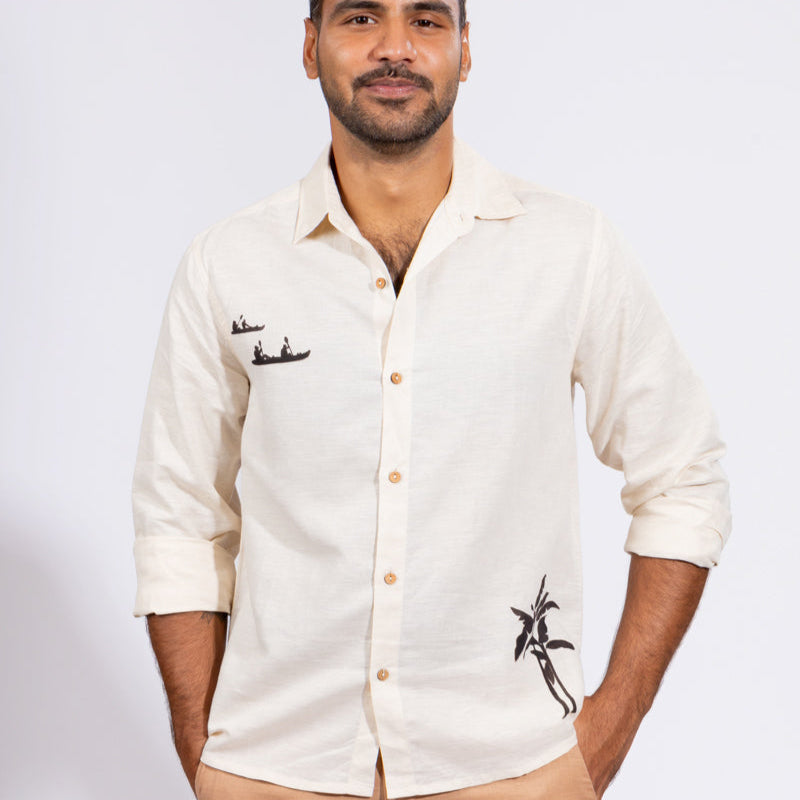 Man wearing a white shirt with embroidery and beige pants on a white background