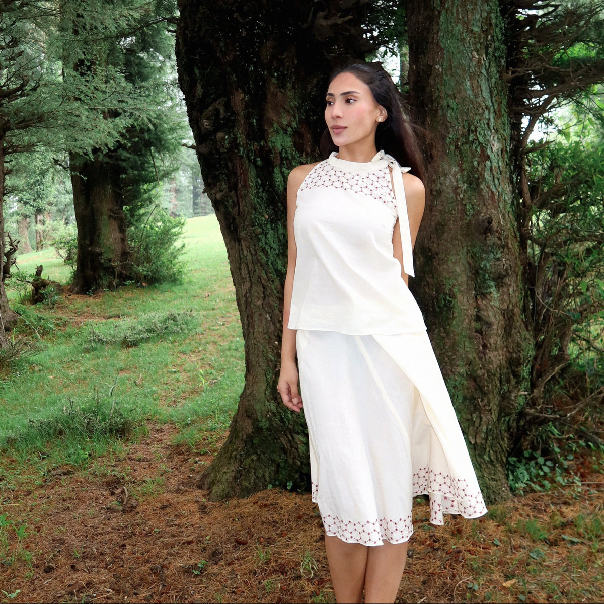 Woman in a white dress standing in a forest