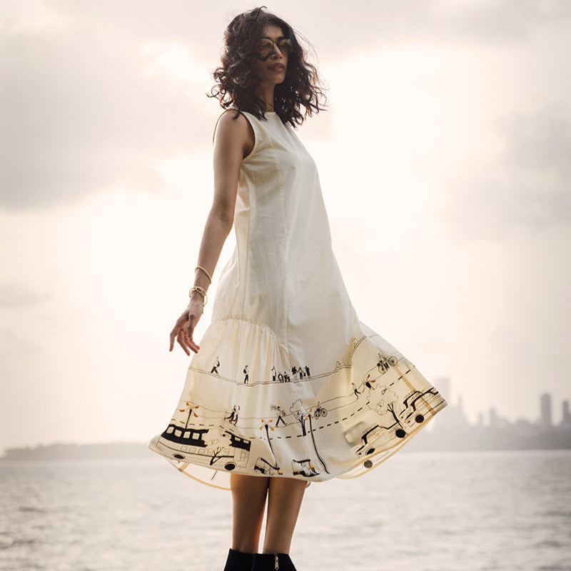 Woman in a white dress with musical notes standing by a waterfront.