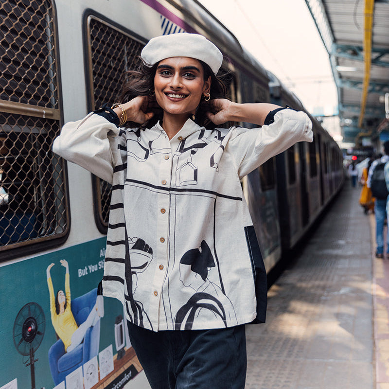 Woman posing in front of a Western Railway train at a station platform.